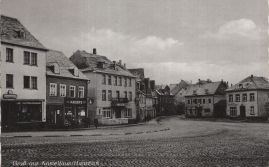 Hier geht es zur Karte mit dem Motiv 'Geschäfte an gepflasterter Straße' Hier geht es zur Karte mit dem Motiv 'Geschäfte an gepflasterter Straße'